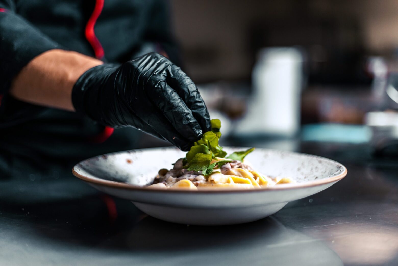 Close up chef serving food in the modern kitchen in a high-end restaurant